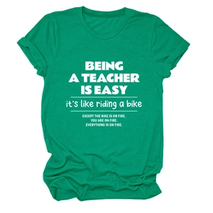 Close-up of green crew neck teacher T-shirt with humorous white quote print and rolled sleeves