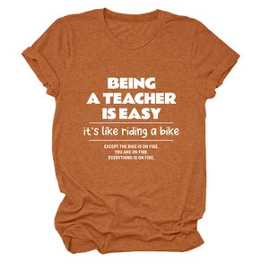 Detail of rust red teacher quote t-shirt showing breathable fabric texture and white print