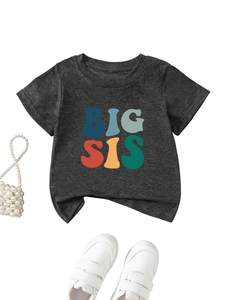 Flat lay of heather grey Big Sis graphic T-shirt for girls with white shoes and pearls