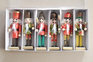 Detail of six hand-painted wooden Nutcracker soldier ornaments in a white gift display box