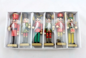 Detailed view of six classic wooden nutcracker soldier ornaments in a white gift box