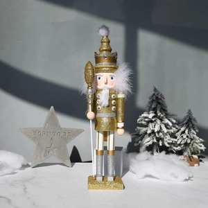 Golden and silver glitter nutcracker soldier with crown and scepter in winter scene