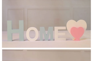 Détail des lettres HOME en bois et décor de cœur rose avec finition mate Morandi