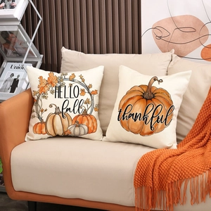 Set of two autumn throw pillow covers featuring pumpkins and Hello Fall on a sofa