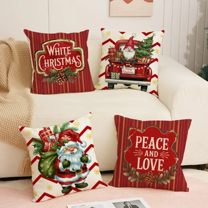 Detail of four Christmas linen pillow covers with Santa and red truck on a sofa