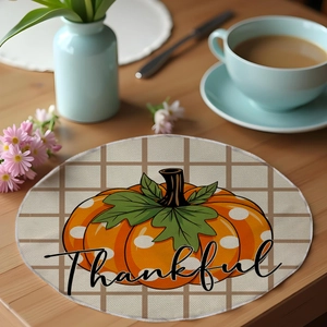Close-up of a linen placemat with a pumpkin design and Thankful script for autumn decor