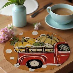 Detailed view of round linen harvest placemat with red truck and pumpkin pattern