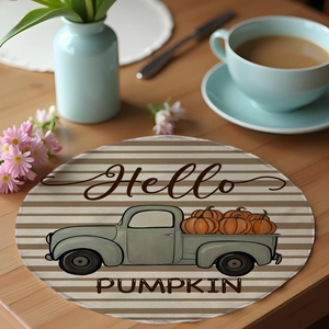 Detail of round linen placemat with harvest pumpkin truck design and Hello Pumpkin text