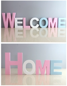Detail of 3D macaron color wooden letters spelling WELCOME and HOME for wall decor