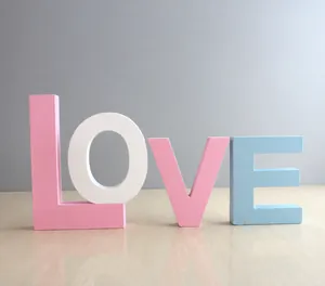 Macro shot of colorful wooden LOVE letter blocks in pastel blue, pink and white finish