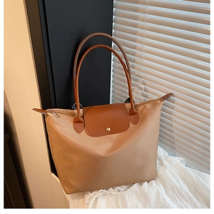 Détail d'un grand sac fourre-tout en nylon kaki avec anses en cuir marron et fermeture