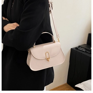 Détail du sac à main crème élégant avec fermoir doré rotatif et rabat en similicuir lisse