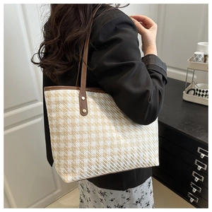 Detailed view of women's tote bag with beige houndstooth fabric and brown leather straps