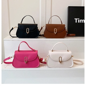 Détails de quatre sacs minimalistes en noir, marron, rose et blanc avec fermoirs dorés