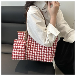 Detail view of red houndstooth tote and mini pouch set with brown leather straps