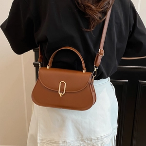 Sacoche selle minimaliste en cuir PU marron avec boucle dorée portée par un mannequin