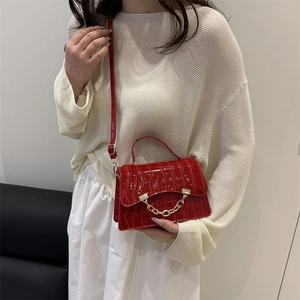 Fashionable red croc-embossed handbag with gold chain detail and adjustable strap