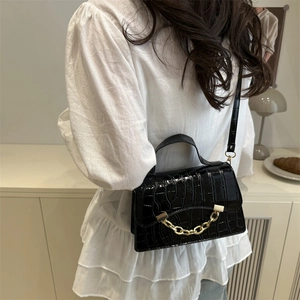 Fashionable black crocodile texture handbag with gold chain detail and shoulder strap