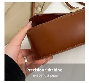 Detailed close-up of precise stitching and smooth leather texture on a brown baguette bag