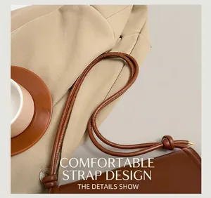 Detail of a brown leather bag showing a comfortable shoulder strap with knot and metal tips