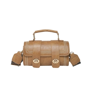 Brown vintage cylindrical crossbody bag with dual gold twist locks and floral strap