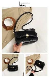 Detail of black PU leather shoulder bag featuring a brushed gold metal lock and knot strap