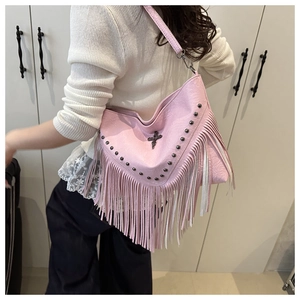 Detail view of pink PU leather bag featuring metal rivets, cross buckle and long tassels