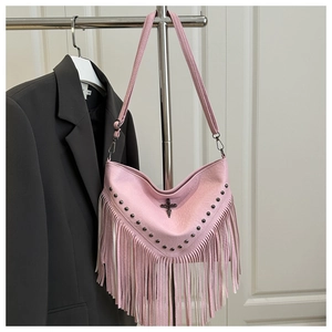 Detailed close-up of pink fringe shoulder bag with metal cross and rivet decorations