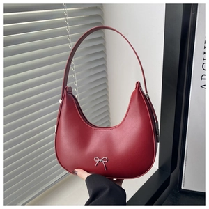 Close-up of red matte leather hobo bag with a delicate silver bow metal ornament