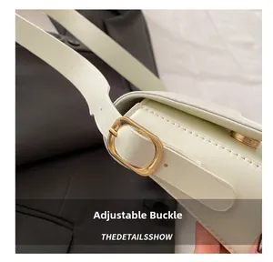 Detail of adjustable gold buckle and premium cream leather on minimalist shoulder bag
