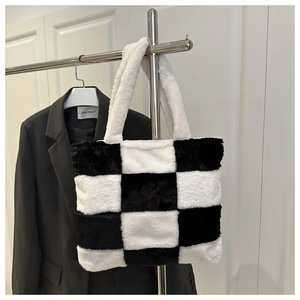 Détail macro de la texture et du matériau du sac cabas en fausse fourrure à carreaux noir et blanc