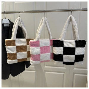 Trois sacs cabas en peluche à damier en marron, rose et noir suspendus pour exposition