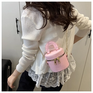 Mini sac cylindrique rose avec double fermeture éclair et bandoulière sur modèle