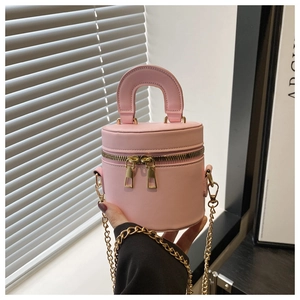 Détail du sac seau rose cylindrique avec double fermeture éclair et chaîne dorée