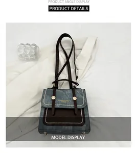 Detailed view of two-tone blue textured shoulder bag with studs and metal feet