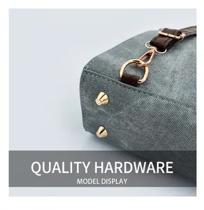 Detailed macro shot of premium golden hardware and protective studs on a grey handbag