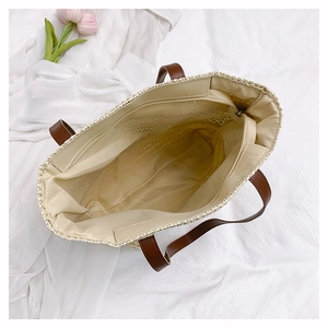 Top view of woven straw tote bag showing spacious fabric lining and inner zipper pocket