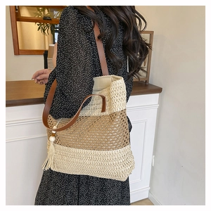 Detail of hand-woven tote bag with beige stripes, leather straps, and stylish tassel