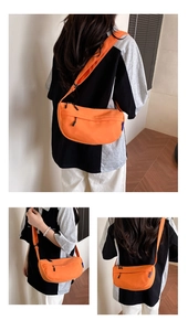 Detail view of bright orange nylon crescent crossbody bag with adjustable wide strap