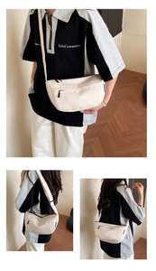 Detail view of cream crescent crossbody bag with front zipper and adjustable strap