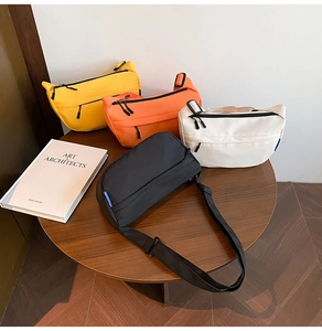 Detail of four colorful nylon crossbody bags on a wooden table with adjustable straps