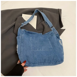 Detail of blue denim tote bag showing decorative stitching and frayed edge details