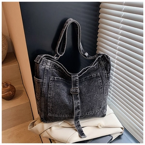Close-up of washed denim tote bag with functional multi-pockets and adjustable strap
