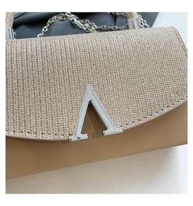 Detail of glitter flap and smooth nude leather on evening bag with metallic V-buckle