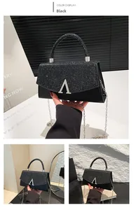 Detail of black crossbody bag featuring silver sequins, A-letter buckle and chain strap