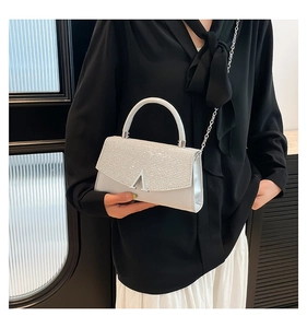 Detail of silver glitter square bag with metal A-buckle and elegant chain strap