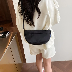 Minimalist black nylon crescent crossbody bag with adjustable wide strap for daily use