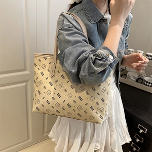 Minimalist beige tote bag with bear pattern and double straps shown on a model