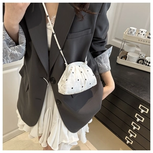 Detail of white floral patterned cloud-shaped crossbody bag with elegant pleated texture