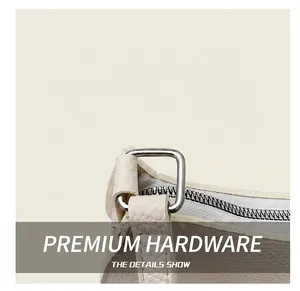Detail of silver metal hardware and lychee grain texture on off-white baguette bag